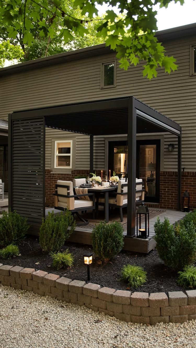A black pergola sheltering a dining table with cream chairs on a backyard deck.