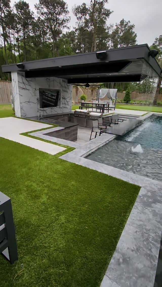 Backyard Pool Bar Ideas: 10 Upgrades for Summer Entertaining 6 Modern black pavilion with marble walls overlooking a swimming pool and lounge area.