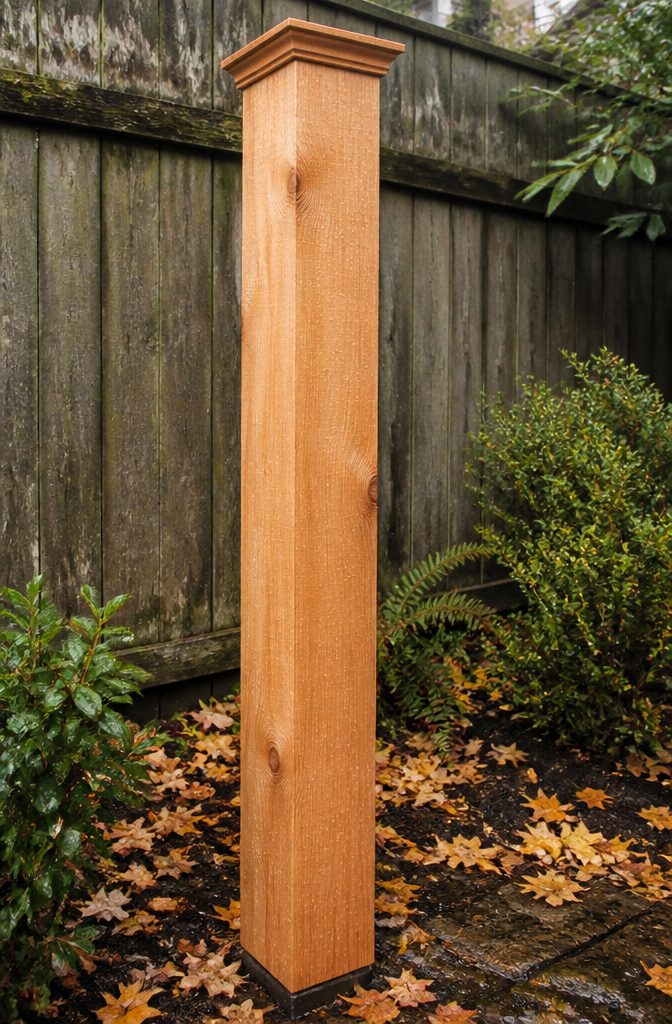 Cedar Wrapped Porch Posts: Styles, Sizes, and Wood Alternatives 6 A cedar post beside a weathered wooden fence.