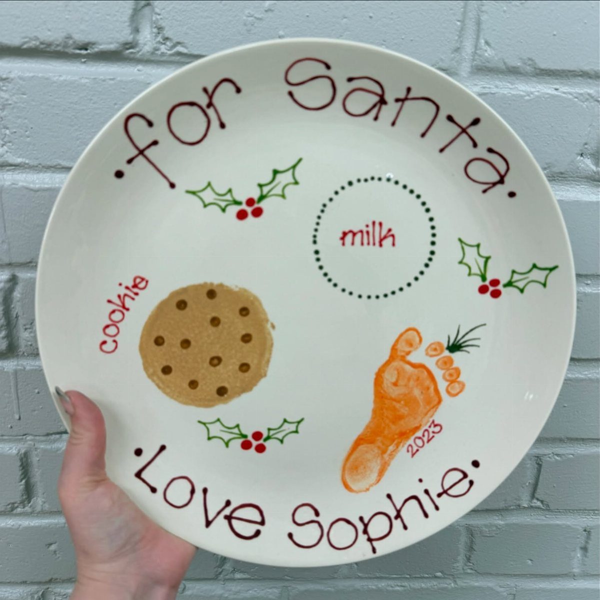 A decorated white plate with hand-drawn cookies, carrots, and text for Santa.