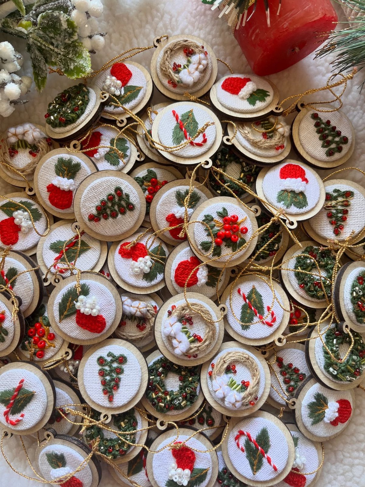 12 Christmas Family Craft Ideas: Projects for All Ages 12 Numerous small circular embroidery hoop ornaments with festive Christmas designs scattered on a white surface.