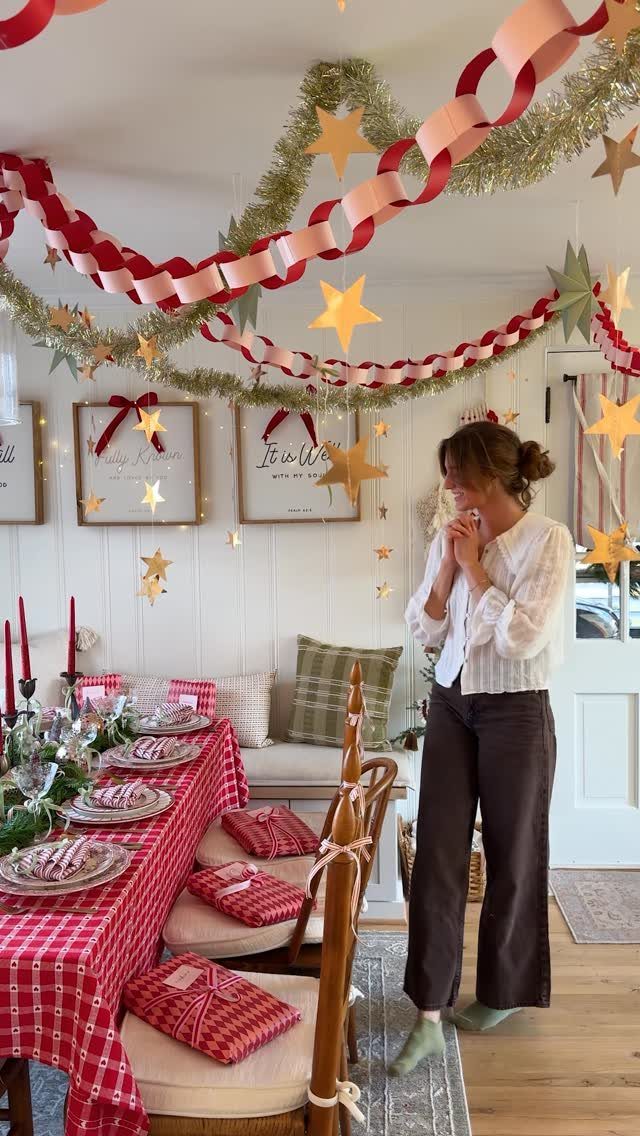 Christmas decorations including star garlands and red streamers hanging above a festive dining table.