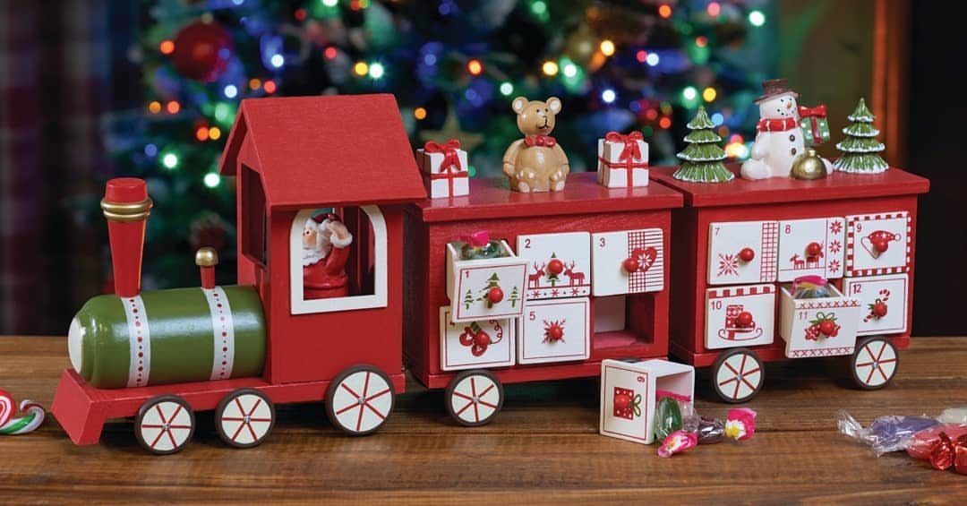 A red wooden toy train Advent calendar with small drawers and festive miniature decorations.