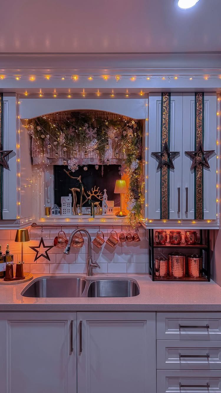 Festive kitchen setup with fairy lights, greenery, and decorative items displayed in a window pass-through.