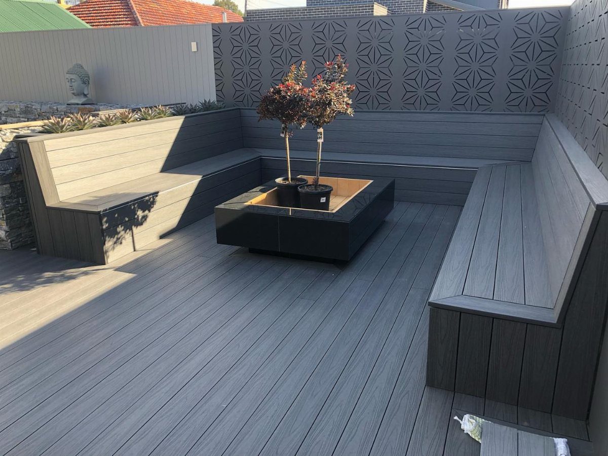 Grey composite deck with built-in L-shaped benches and a central planter box.