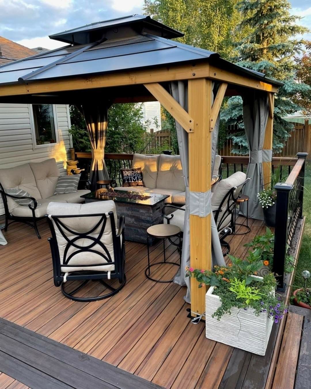 8 Deck with Roof Ideas for Every Backyard Layout 3 Wooden gazebo with a dark metal roof situated on a wooden deck with outdoor furniture.