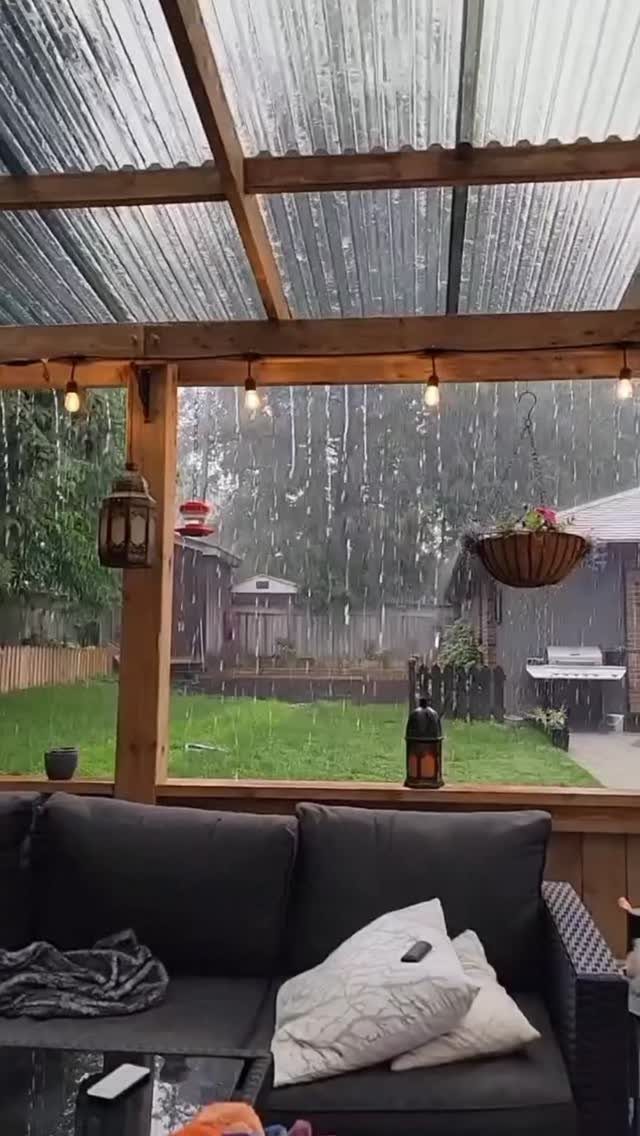 8 Deck with Roof Ideas for Every Backyard Layout 7 Translucent corrugated roofing panels over a wooden deck structure during a rainstorm in a backyard.