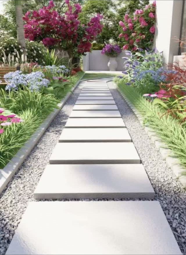 16 Front Lawn Landscaping Ideas for Curb Appeal 3 Rectangular stone pavers form a modern walkway through a lush garden with pink flowers.