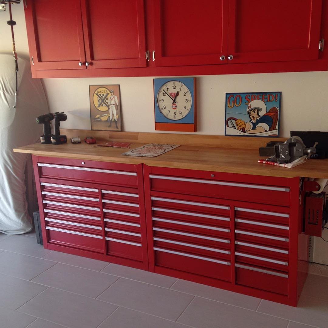 Garage Workbench Ideas: 11 Builds from IKEA Hacks to Heavy-Duty 11 Red tool chest cabinets supporting a long wooden workbench surface against a white wall.