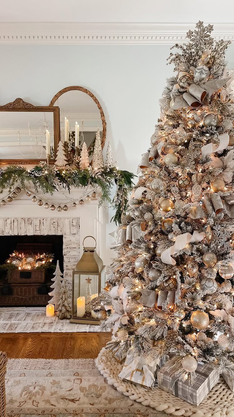 Decorated white mantel with evergreen garland and candles next to a glittering Christmas tree.