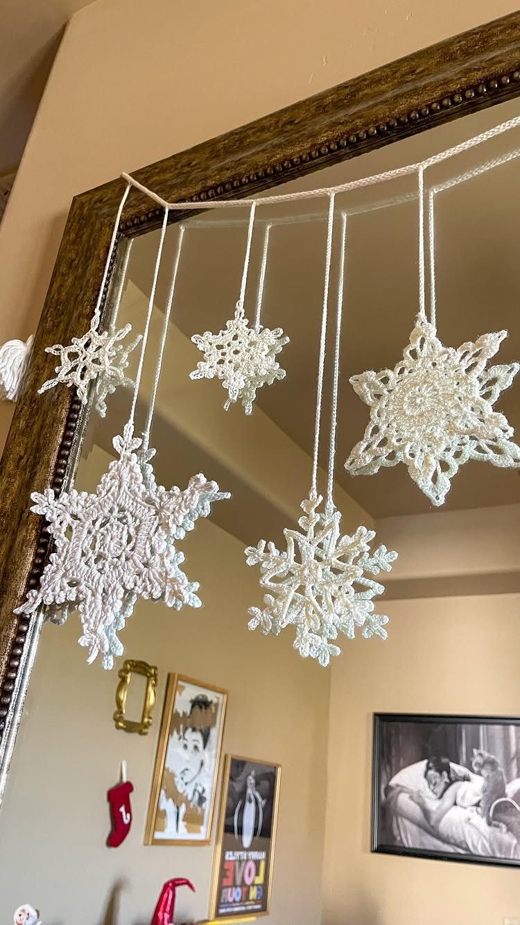 Homemade Christmas Ornament Ideas: 8 Easy Projects 6 White crocheted snowflake ornaments hanging from a string in an indoor setting.