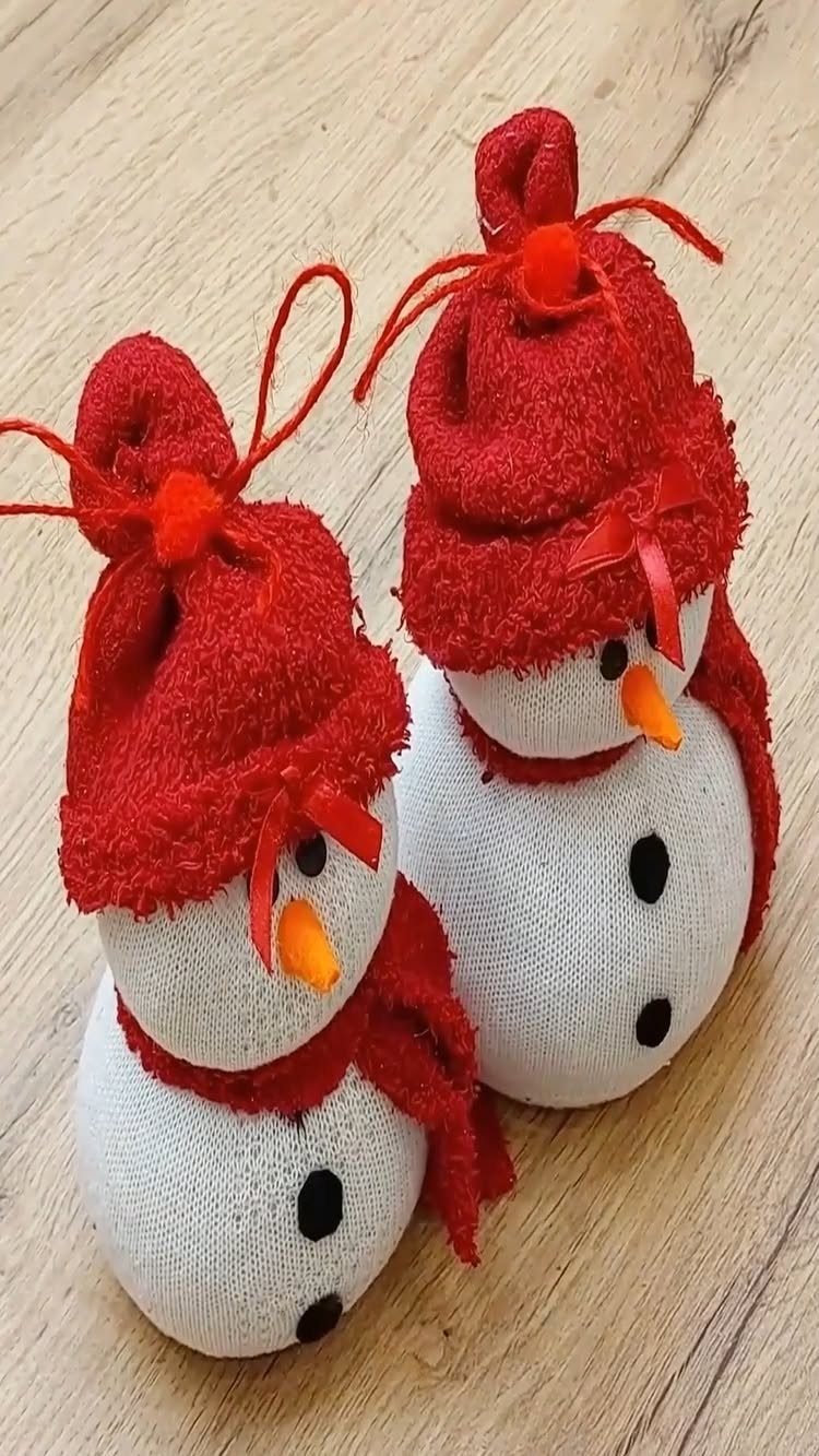 Homemade Christmas Ornament Ideas: 8 Easy Projects 4 Two handmade sock snowmen with red hats and orange noses on a wooden surface.
