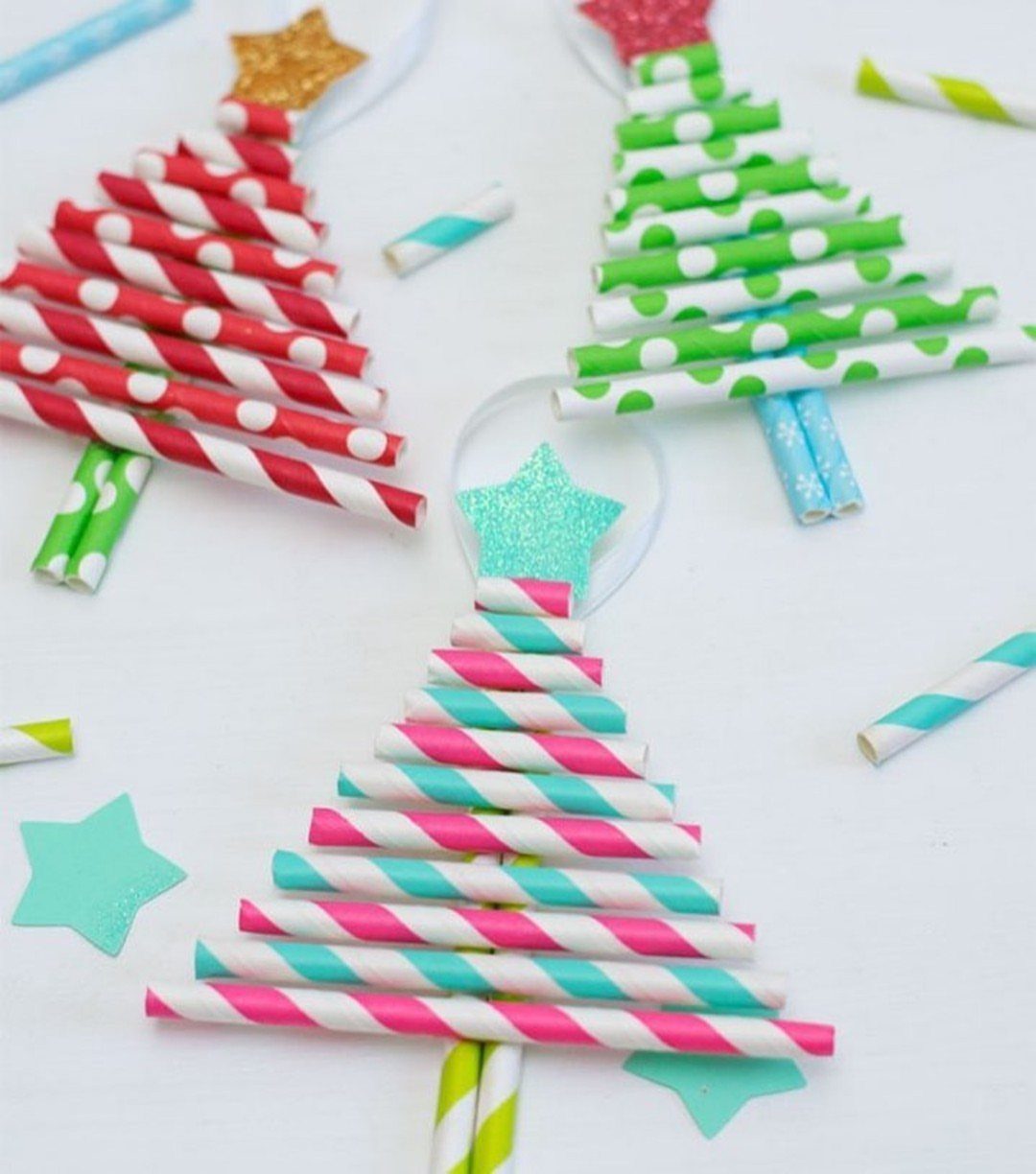 Three Christmas trees crafted from colorful striped and polka-dotted paper straws on a white background.