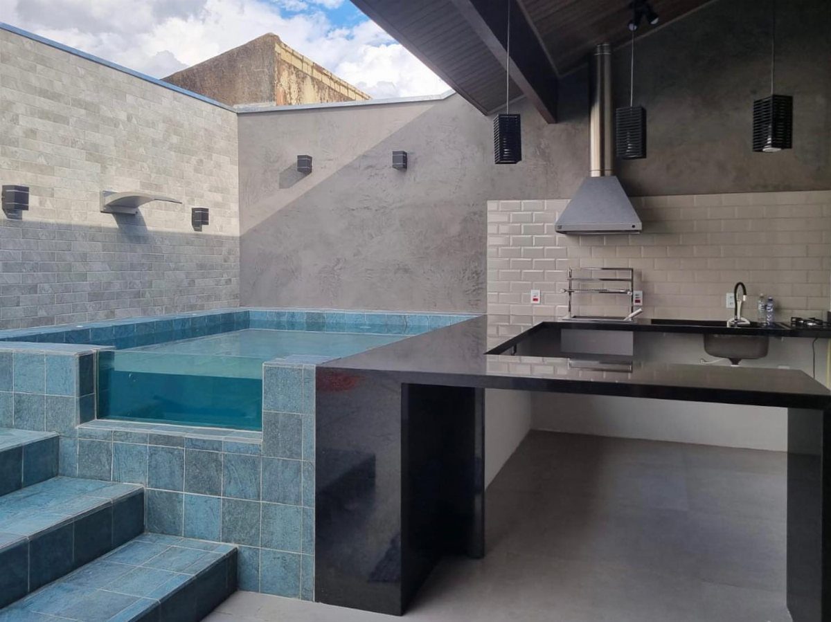 11 Outdoor Kitchen with Pool Ideas That Actually Work 6 A modern compact outdoor kitchen with black counters next to a small blue tiled plunge pool.