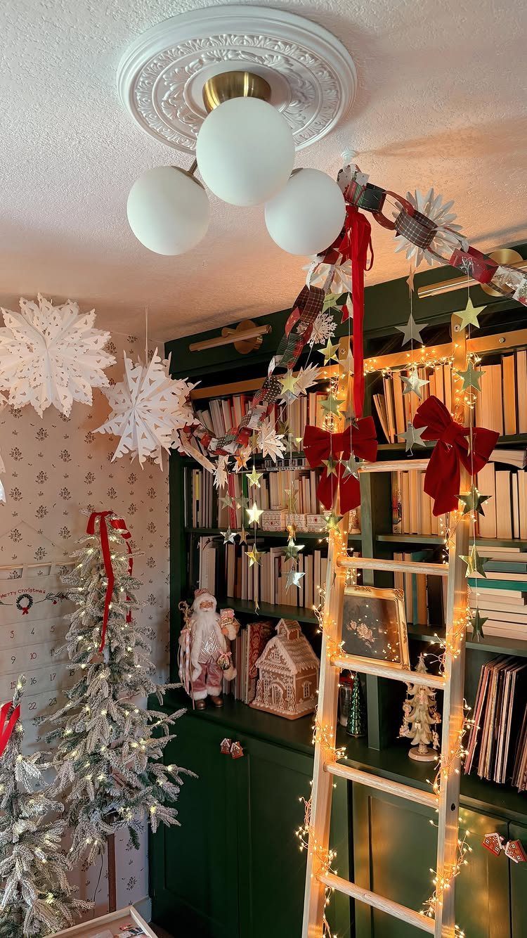 Decorated green bookshelf with festive garlands, red bows, star ornaments, and a small flocked Christmas tree.